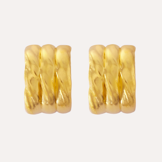 A pair of gold, textured earrings with a sculptural design. Large stud earrings.