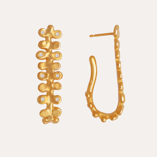 A pair of gold earrings featuring an organic design with small gemstones.