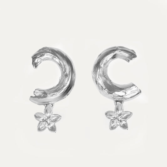 A pair of recycled silver earrings featuring a floral design attached to a crescent shape