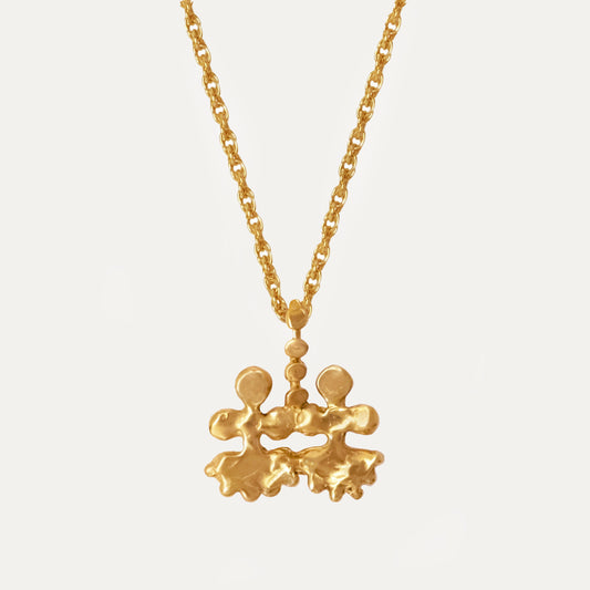 A gold vermeil necklace featuring a twin idol pendant design, with intricate details and a gold-filled chain.