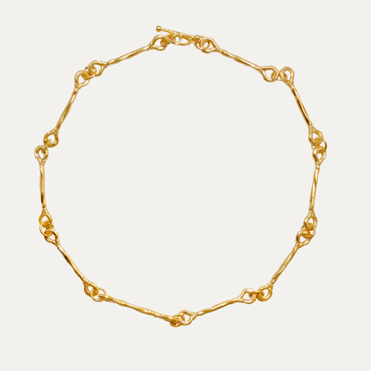 An elegant gold-colored choker necklace with adjustable length, featuring a micron thick 18k gold plating on recycled sterling silver.